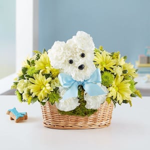 White teddy bear in a basket surrounded by yellow flowers