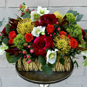 Red roses and white blooms in a gold-textured container