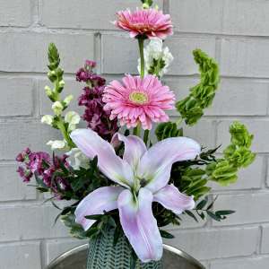 Pink lilies and gerbera daisies in a green vase