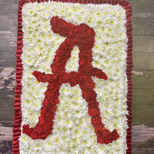 Red and white floral standing tribute with a ribbon border