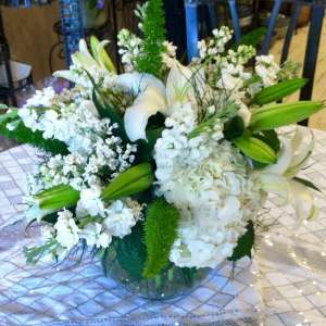 White floral arrangement with lilies and hydrangea in a glass vase