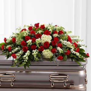 Red roses and white flowers arranged on a casket