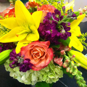 Bouquet with yellow lilies, coral roses, and purple flowers