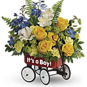 Yellow and blue flower arrangement in a red “It’s a Boy!” toy wagon container