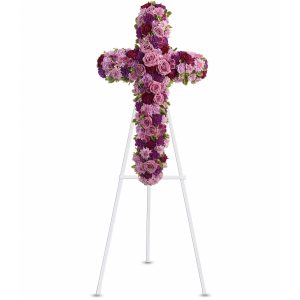 Standing cross-shaped spray of pink and purple flowers on a white easel.