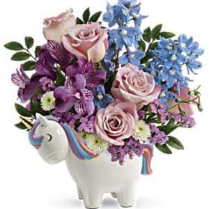 Pastel roses and purple blooms in a white unicorn-shaped ceramic container