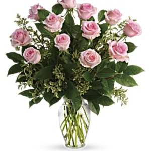 Arrangement of light pink roses in a clear glass vase.