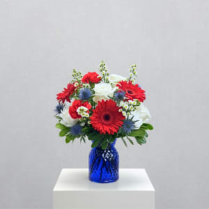 Red and white mixed bouquet in a blue glass vase