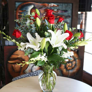 Red roses and white lilies in a clear glass vase