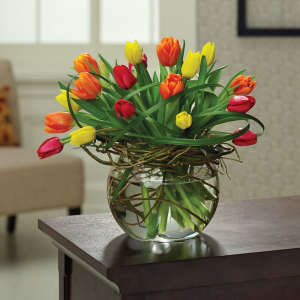 Colorful tulips arranged in a round glass vase