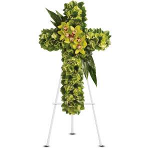 Standing cross of green flowers with yellow orchids on a white easel