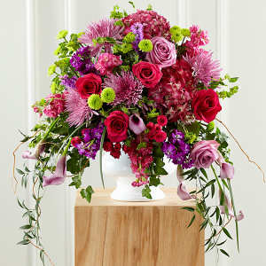 Large bouquet of pink and red flowers in a white vase