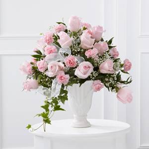 Pink roses and carnations arranged in a white vase