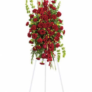 Tall standing arrangement of red roses and carnations on a white easel