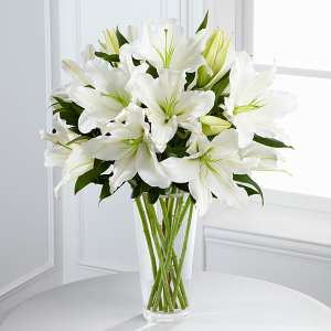 White lilies arranged in a clear glass vase