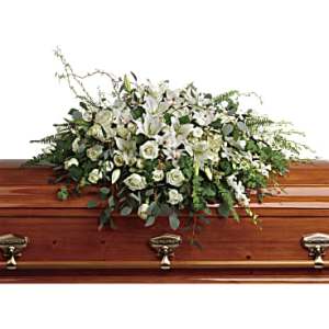 White floral spray on a wooden casket