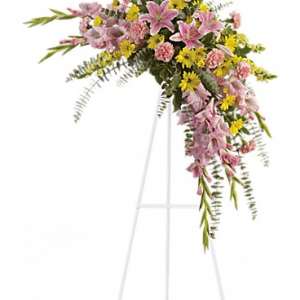 Pink and yellow floral spray on a white easel stand