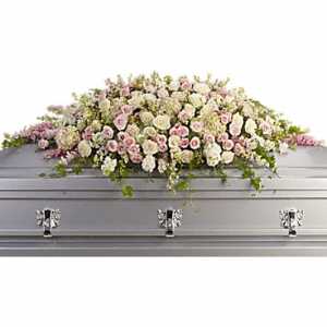 White and pink floral casket spray on a silver casket