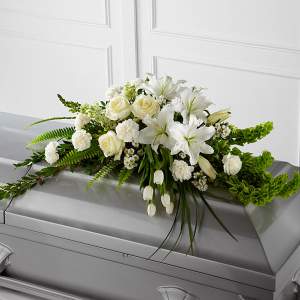 White floral arrangement on a gray casket