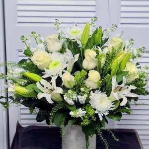 White roses and lilies arranged in a gray vase