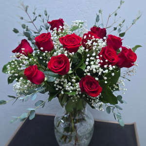 Red roses with baby's breath in a clear glass vase