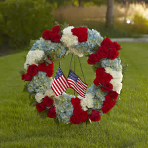 Red, white, and blue floral wreath with small American flags