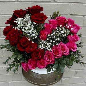 Bouquet of red and pink roses with white baby's breath in a vase
