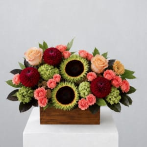Mixed bouquet with sunflowers, roses, and dahlias in a wooden box