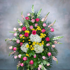 Large standing arrangement of pink roses, white hydrangeas, and yellow daisies