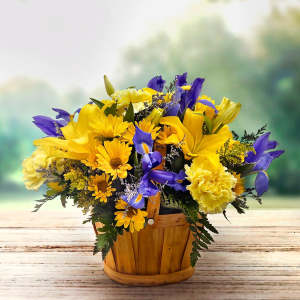 Yellow and purple mixed flower arrangement in a wooden basket