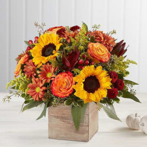 Autumn bouquet with sunflowers, roses, and mums in a wooden box
