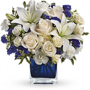 White lilies and roses in a blue glass vase