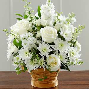 White roses and daisies arranged in a woven basket