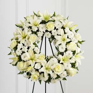 White floral wreath on a black stand