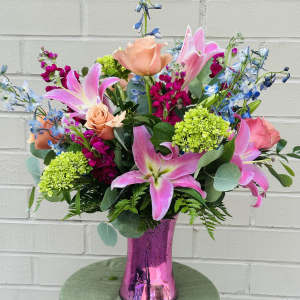 Pink lilies and roses in a metallic pink vase