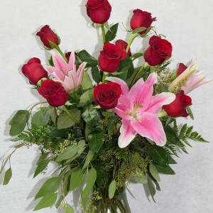Bouquet of red roses and pink lilies in a clear glass vase