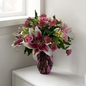 Pink and white mixed bouquet in a purple glass vase