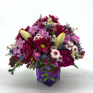 Magenta and lavender mixed bouquet in a purple glass vase