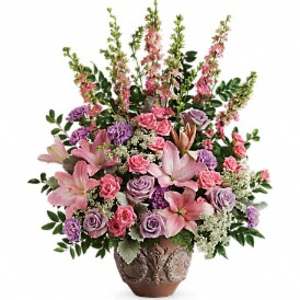 Tall pink and lavender floral arrangement with lilies and roses in a decorative brown pot
