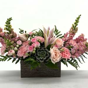 Pink floral arrangement in a rectangular wooden box