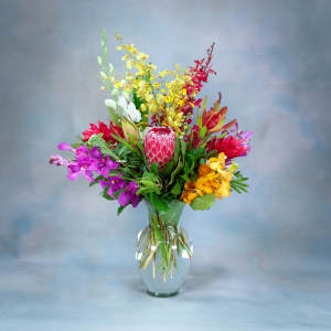 Colorful tropical flower arrangement in a clear glass vase
