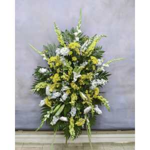 Large standing floral spray with yellow and white flowers on an easel