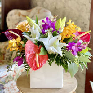 Colorful bouquet with lilies, orchids, and anthuriums in a white vase