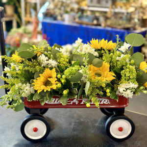 Yellow sunflower arrangement in a red wagon with white flowers