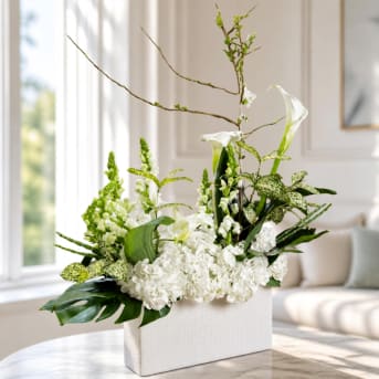 White floral arrangement in a rectangular vase with tall branching stems