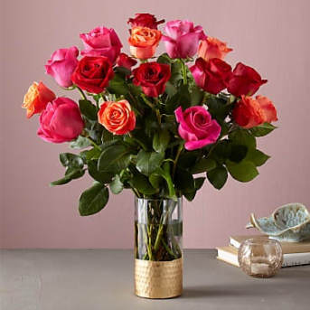 Bouquet of red, pink, and orange roses in a glass vase