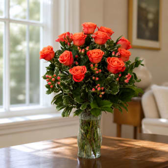 Orange roses arranged in a clear glass vase