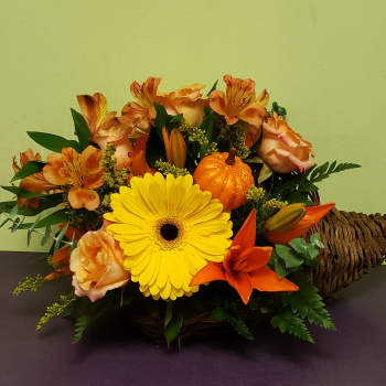 Basket arrangement with yellow gerbera, orange lilies, and peach roses