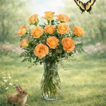 Orange roses in a clear glass vase with a butterfly and rabbit nearby