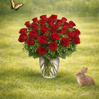Red roses arranged in a clear vase with a butterfly and rabbit nearby